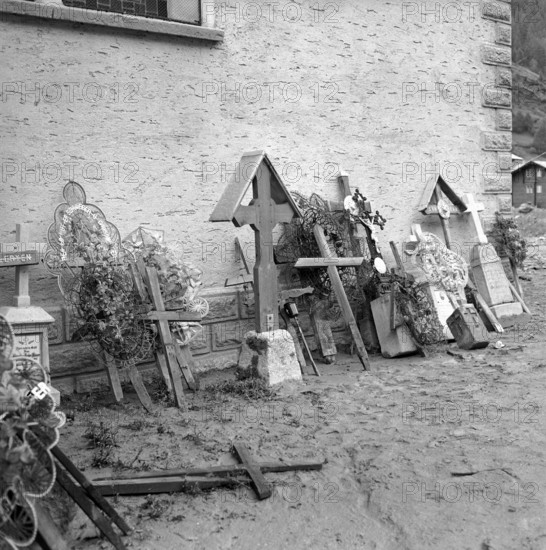 Täsch; gravestones and grave crosses damaged by debris flow; 1957