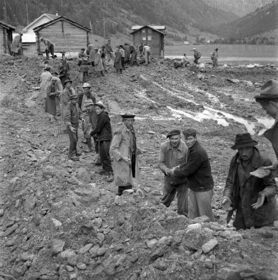Men doing cleanup work in the Valais village of Täsch; 1957