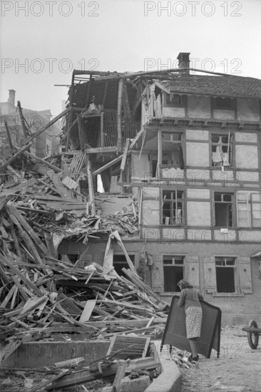 WW 2: bomb airdrop, dropping. woman in front of destroyed house, Schaffhausen 1944