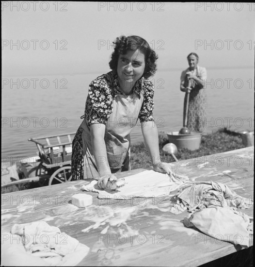 Women scrubbing laundry with a brush; washing at Lake Constance, 1944