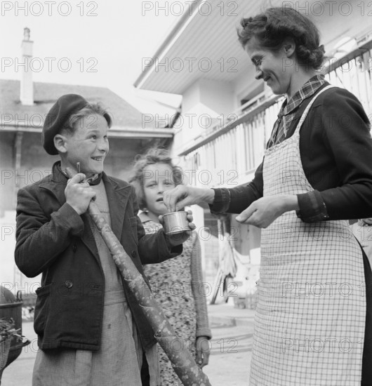Boy receives a small reward for blowing the horn, 1944