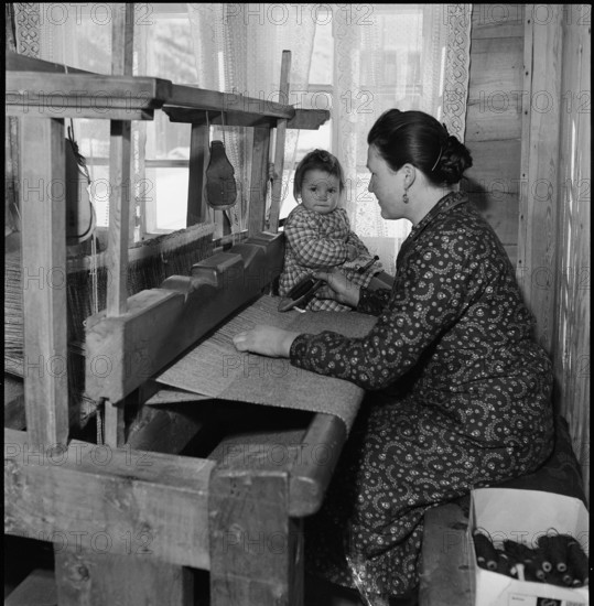 Woman with child at the loom, 1945.