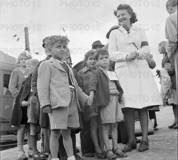 Red cross nurse with children from Domodossola; identification badge; 1944.