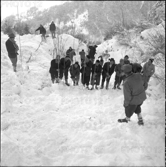 Three workers buried by avalanche near Grindelwald: men searching for the missed persons; 1956.