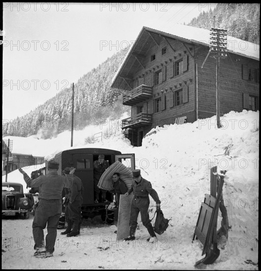 Jaun, 29 buildings destroyed by avalanche in the evacuated village, people taking away household effects; 1954.