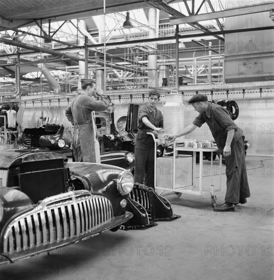 Factory workers have a break; assembly hangar; General Motors 1946.
