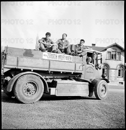 Men on truck to transport the collected potatoes.