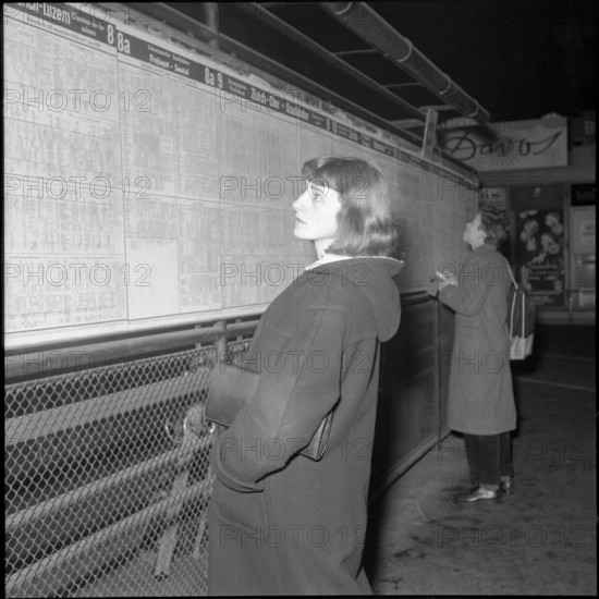 Woman studies the Timetable, 1956.