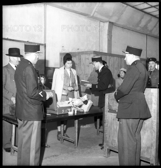 Custom officers checking woman at the customs office at Geneva-Cornavin, 1946.