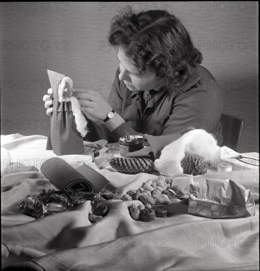 Woman making a Santa Claus doll in 1944.
