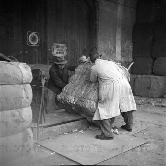 WW 2: economy of war; weighing of bundle of rag, rags.