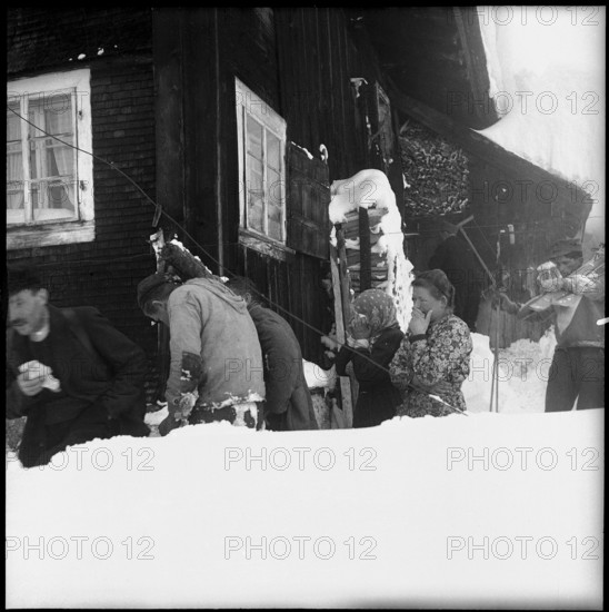 Avalanche in Spiringen, Schächen valley: people mourning for avalanche victim;  1954.