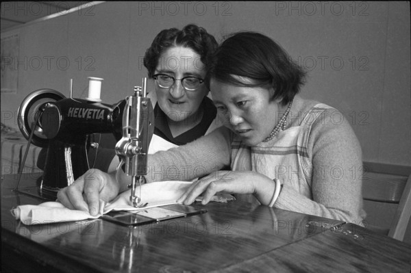 Tibetan woman learning to sew by sewing machine, Waldstatt 1962.