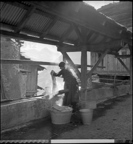Woman doing the washing in village in Valais.