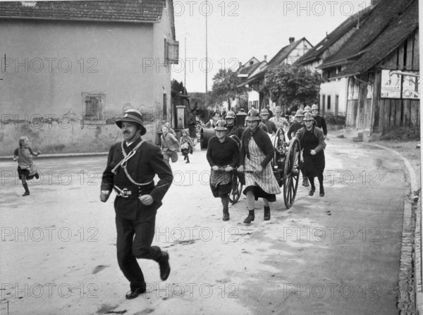 Women of the auxillary fire brigade with hose cart, 1941.