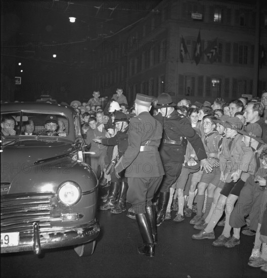 People crowding round car with Henri Guisan, Neuchatel 1949.