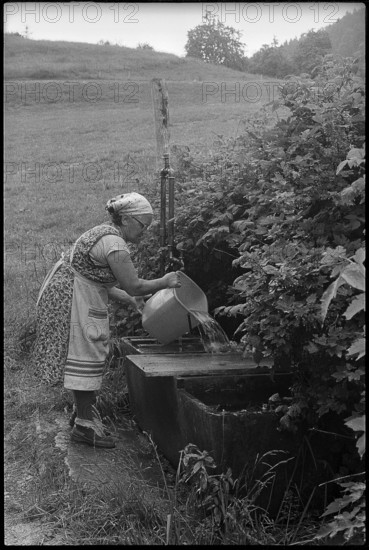 Old farmer at a fountain, Switzerland 1971.