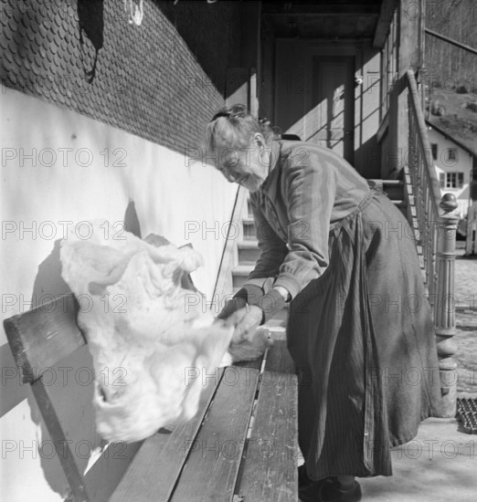 Old woman with wool to spin yarn, 1941.