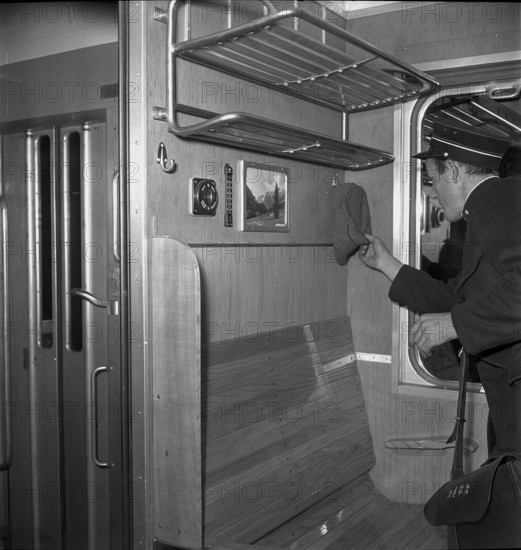 Coductor finding military cap in railroad car, Oensingen 1949.