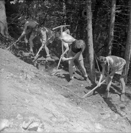 Isenfluh, volunteers building access road to mountain village; 1959.