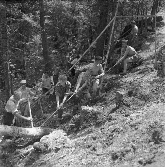 Isenfluh, volunteers building access road to mountain village; 1959.