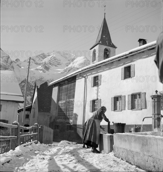 Latsch GR: washday, woman washing at fountain; 1939.