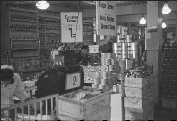 Salesperson in a food shop; soup on offer; 1945.