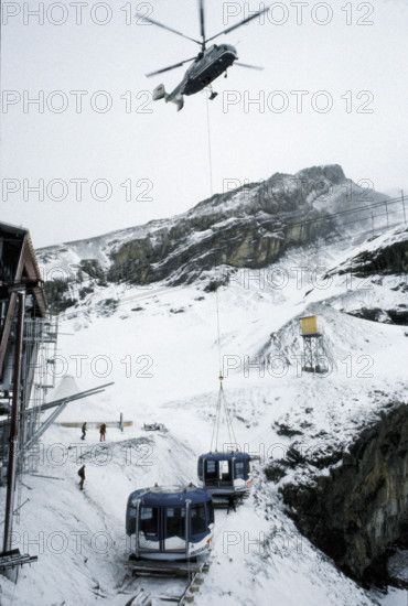 Helicopter transporting cable car cabin.