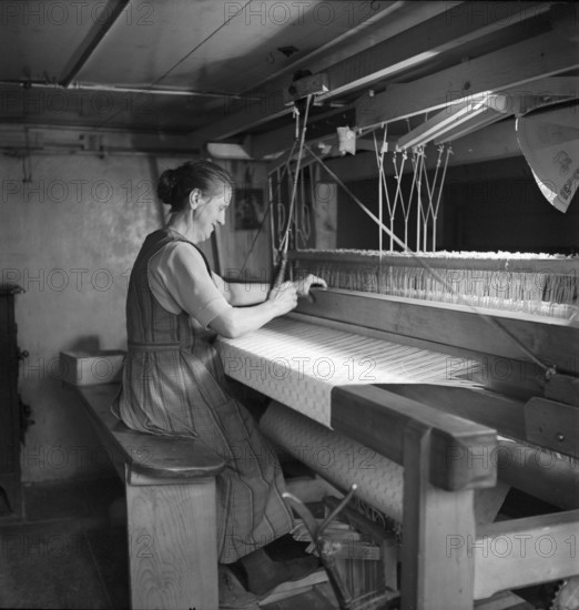 Woman weaving a carpet, 1940.