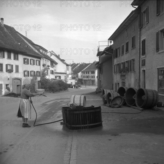 Hallau; woman cleaning wooden tub; 1958.
