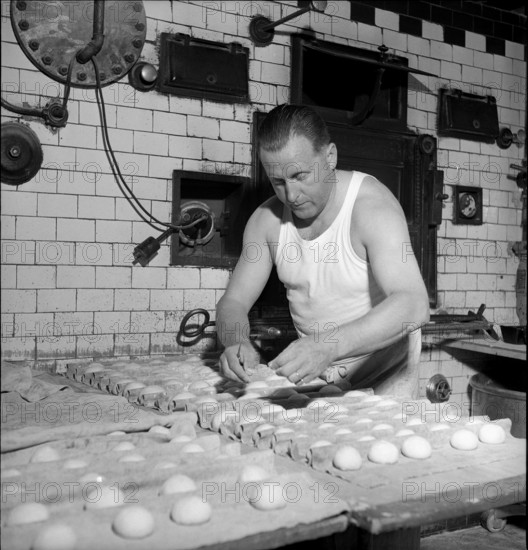 Baker making bread rolls, 1949.