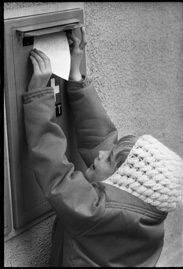 Child throwing a letter into a postbox, 1970.