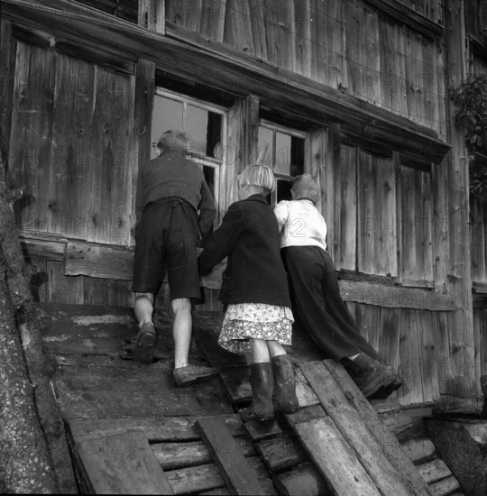 Auction in  Appenzell: nosy children peering through window; 1955.