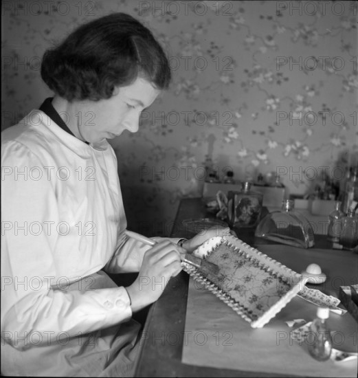 Woman putting ceramic craquelet on dish 1941.