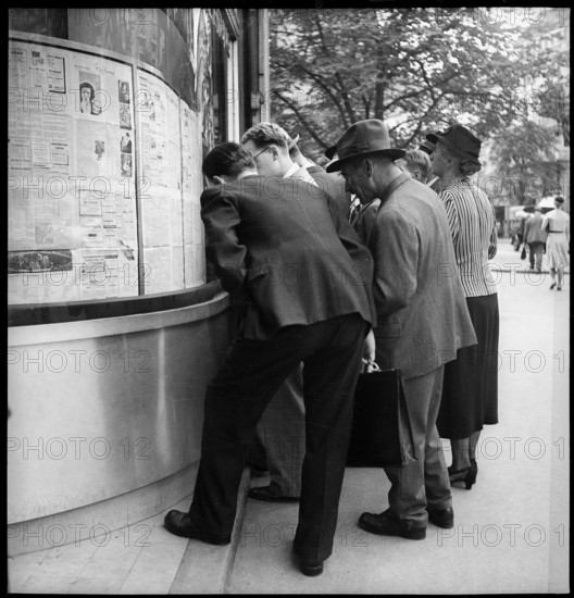 People reading advance sheets of Neue Zurcher Zeitung; 1939.
