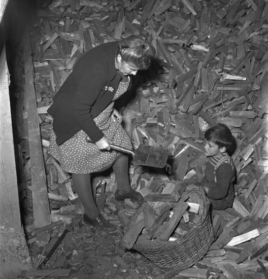Woman finding lost army shovel in firewood storeroom 1949.