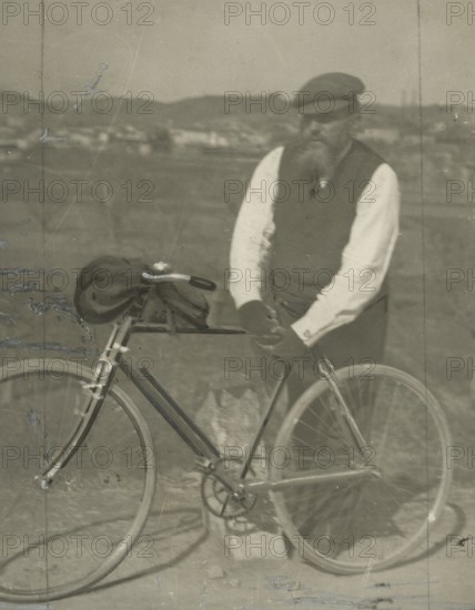 Frederick Johnson next to his bicycle. 
	
		1900-1910