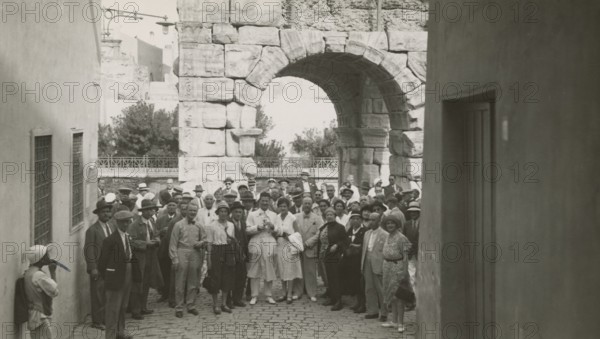 Excursionists in front of the Arch of Marcus Aurelius in Tripoli. 
	
		1931