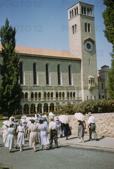People walking towards Winthrop Hall Clock Tower building, University of Western Australia, Perth, Australia 1956.