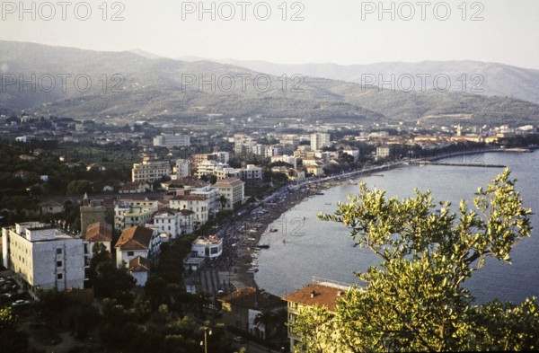 View over beach and buildings, Diano Marina, Imperia, Liguria, Italy, July 1959.