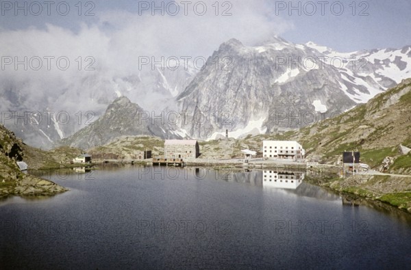 Hospice du Grand Saint Bernard, Pennine Alps, Monastery buildings, Saint Bernard Pass, Valais, Switzerland, July 1959 Alpine peaks and lake Lac du Grand.