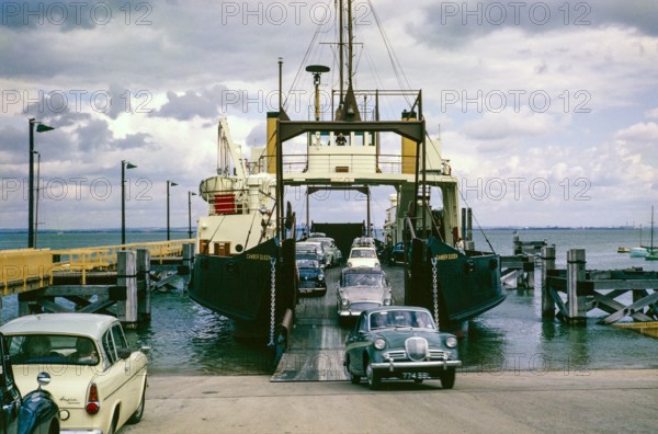 Cars disembarking ferry 'MV Camber Queen' built 1961 from Portsmouth, Fishbourne, Isle of Wight, England, UK, 1962.