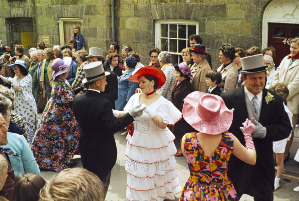 Flora Day, Helston, Cornwall, England, UK 1973 - crowds watch couples perform the  Furry dance in the streets of the town.