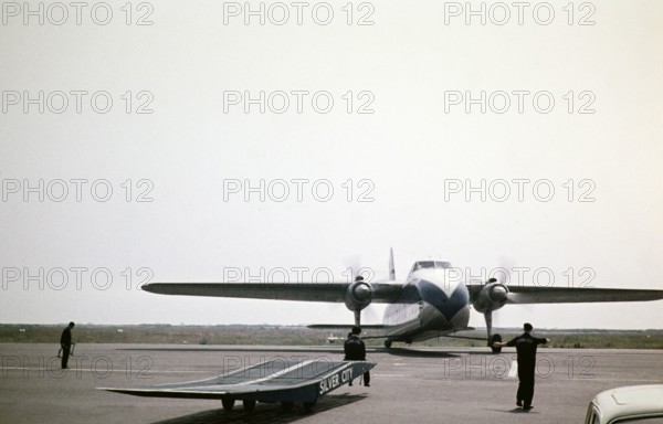 Ground staff direct Bristol Superfreighter plane G-AMWE, Silver City Airways airline air ferry, Ferryfield airport, Lydd airfield, Kent England, UK 1960.