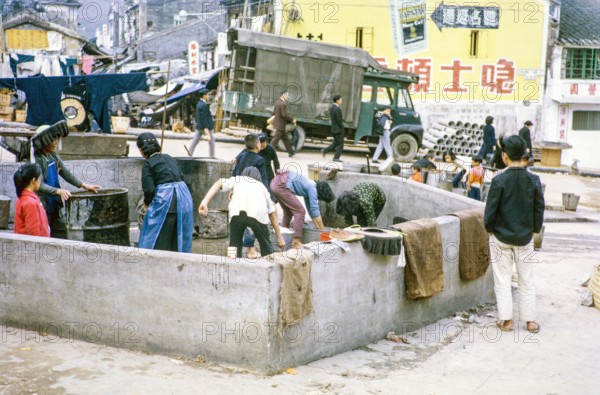 Women washing clothes in street  at public laundry place, Shun Tak Street, Tai Po, New Territories, Hong Kong, Asia, 1964.