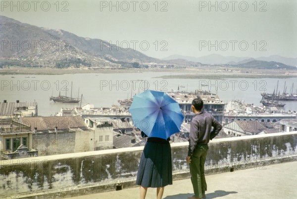 View over rooftops and harbour in city centre from hilltop of Monte Fort, Macau, Asia 1964.