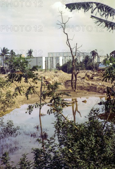 Destruction of farmland for construction site with modern blocks of flats residential housing, Singapore, southeast Asia, 1965.