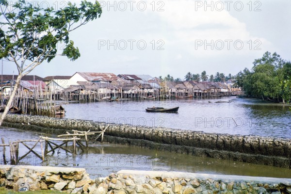 Attap houses and wooden jetties in fishing village on stilts, Singapore, southeast Asia c 1963.