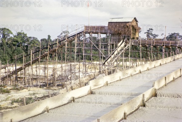 Open Cast gravel-pumping tin mine Malaya, Malaysia, south east Asia 1964  - Ore separation in the Palong, the  palong acts as a processing sluice with riffles or bars.