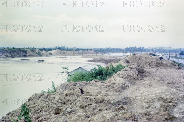Waste spoil heaps polluted tailing ponds environmental impact of large scale tin mining, Batu Gajah, Perak, Malaya, Malaysia, south east Asia 1965.